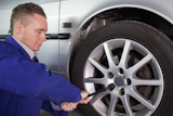 Concentrated mechanic changing a car wheel