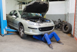 Auto mechanic working on car